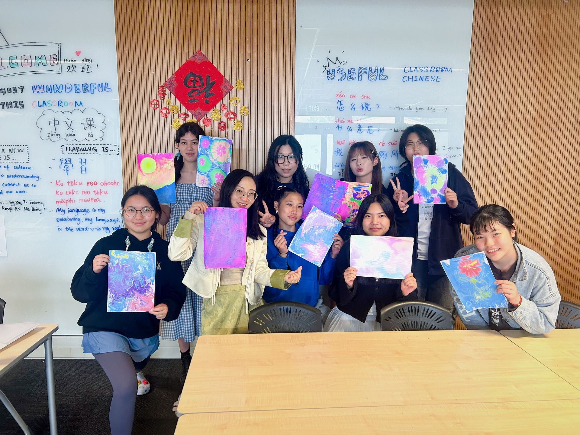 students holding up their art